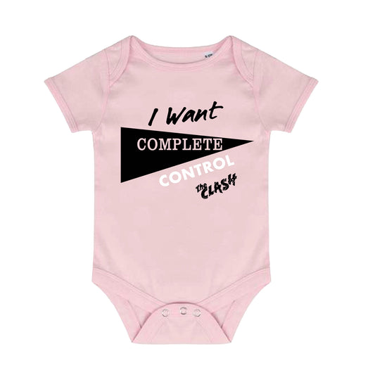 light pink baby grow with 'i want complete control' and the clash logo on the front, black triangle behind 'complete' poppers as the fastening 